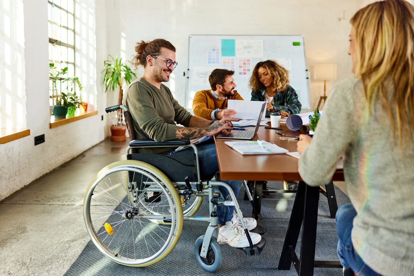 Equipe diversa colaborando em um ambiente de trabalho acessível