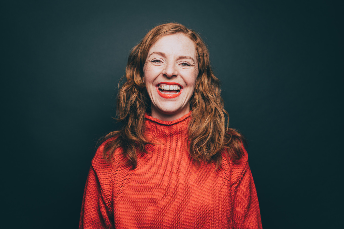 Mulher sorrindo em retrato sobre fundo escuro